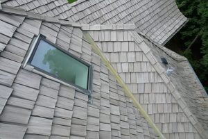 Residential roof shingles and window during insurance inspection.