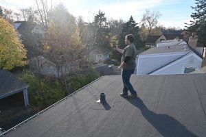 Home inspector assessing roof condition for insurance inspection.