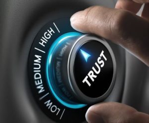 A hand turning a trust dial toward high