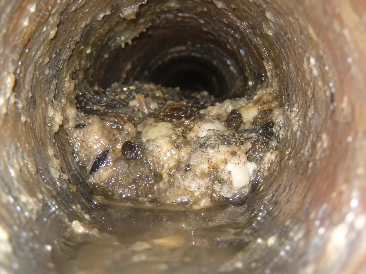 Sewer camera view showing grease debris and accumulated material blocking a sewer line